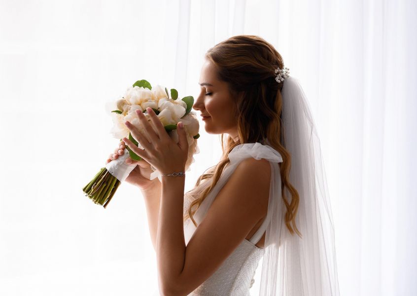 Viridian Central A bride elegantly holds a vibrant bouquet of flowers, symbolizing love and beauty on her special day.
