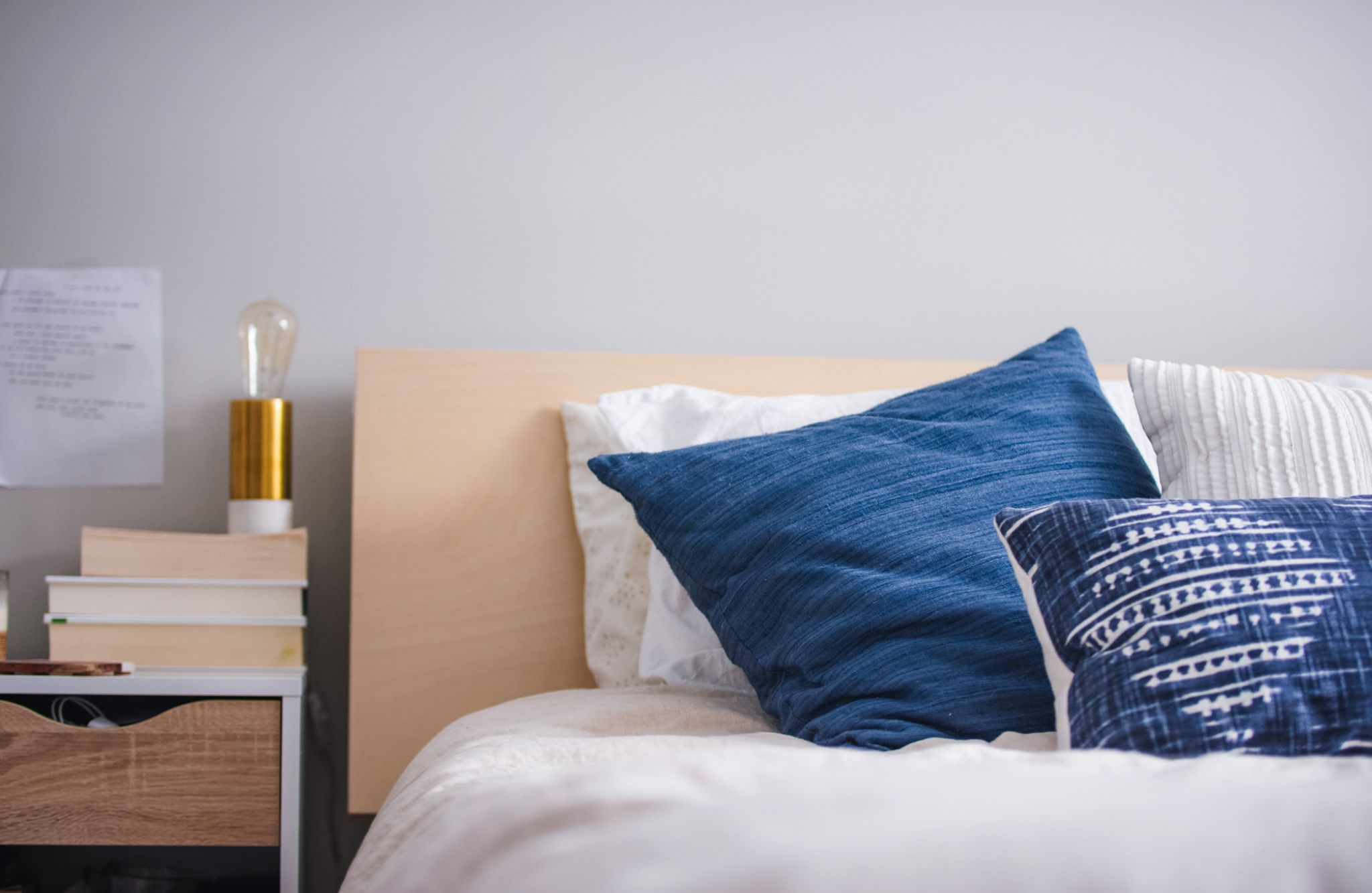 Viridian Central A bed with blue and white pillows and a lamp.